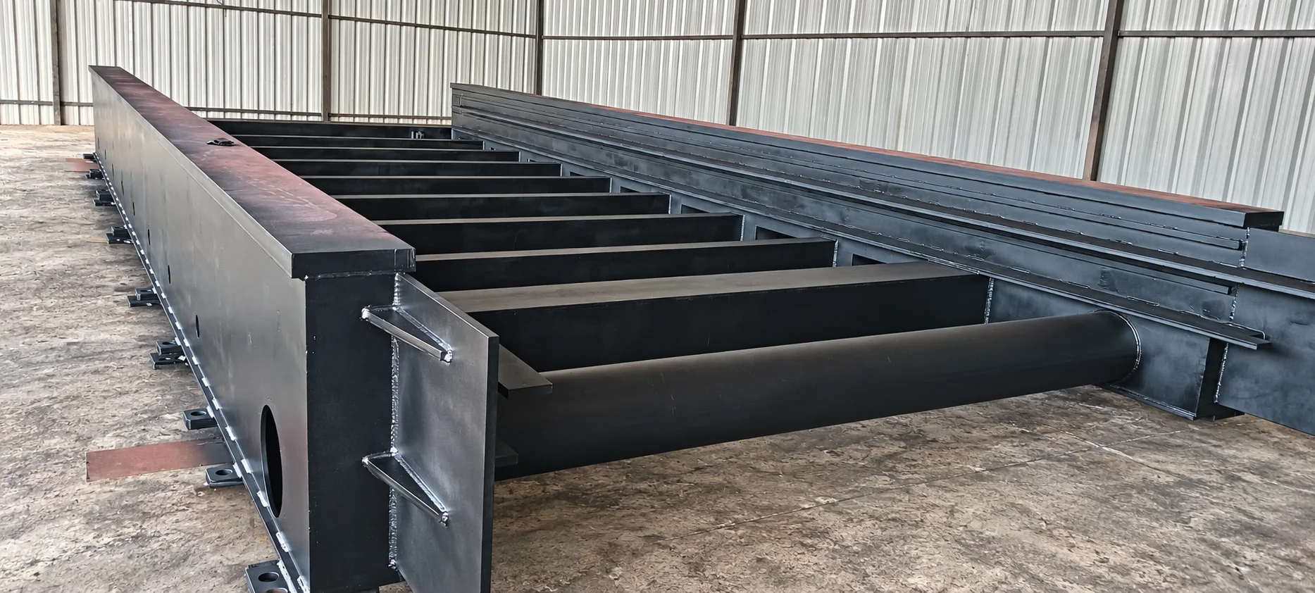Large welded laser machine bed built by Naxos, with its side members and cross members visible